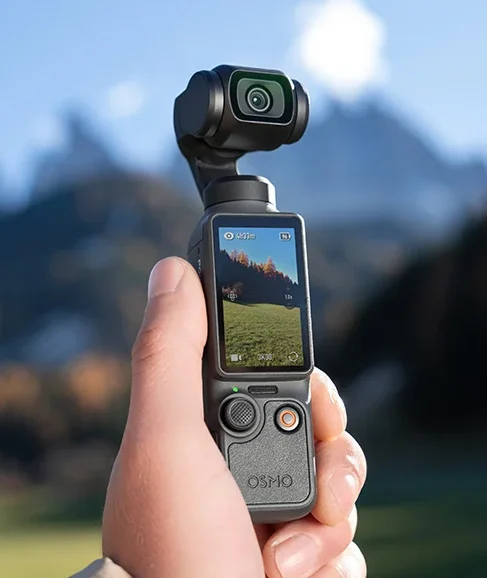 Gimbal DJI Osmo Pocket 4 w dloni na tle gor
